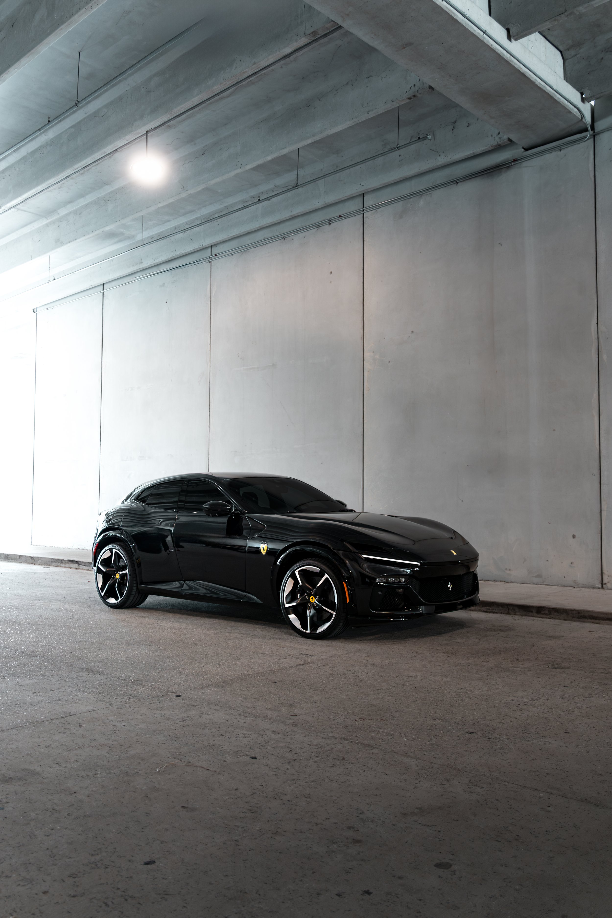 Black Ferrari Purosangue parked in an underground concrete parking garage in Tampa