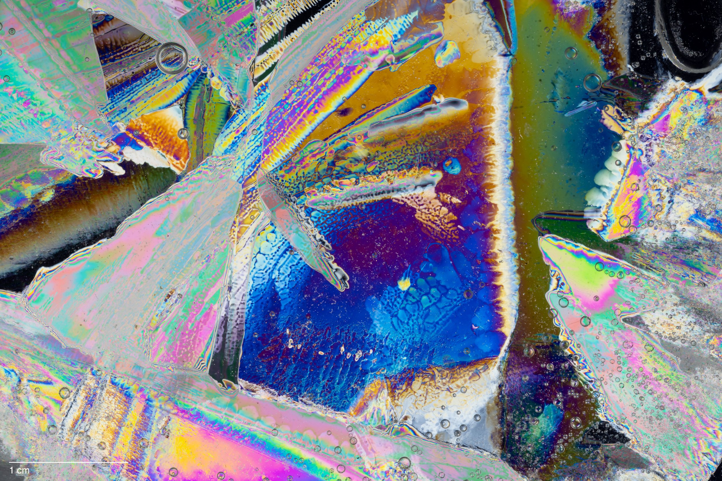 Microscopic cross-polarization of ice with vibrant swirling patterns and textures.
